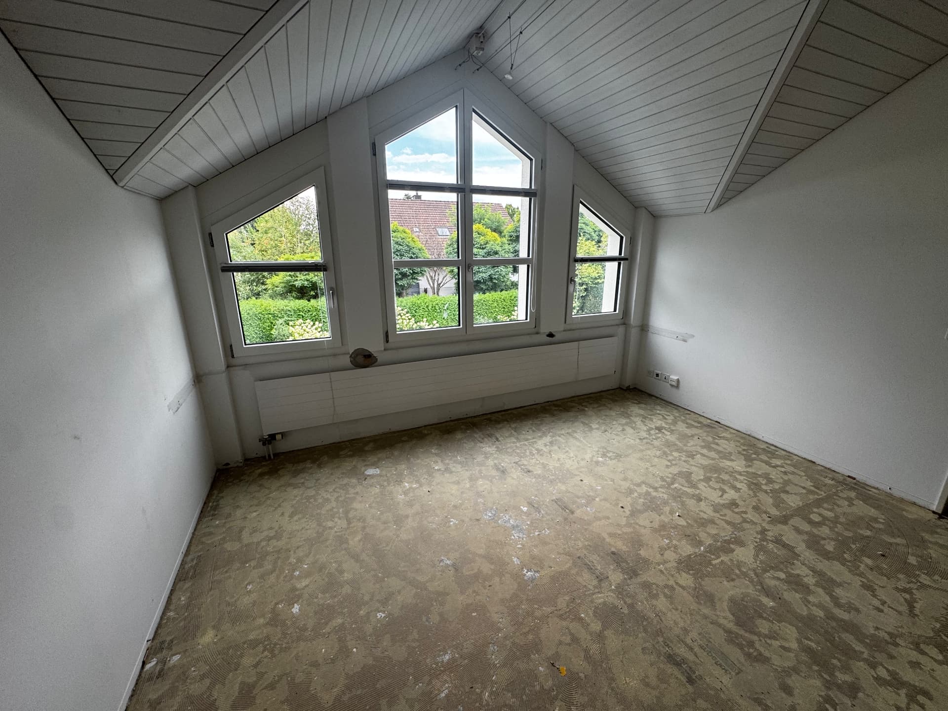Entkernter Raum mit grossem Fenster, Boden freigelegt