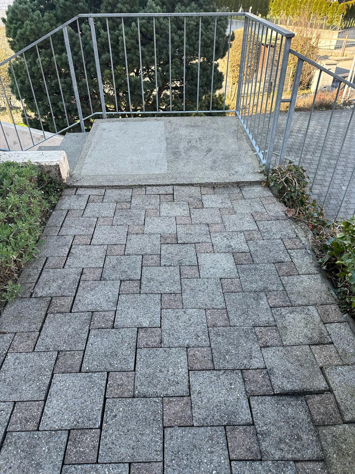 Pflasterweg vor der Sanierung mit unebenen Steinen am Treppenabsatz